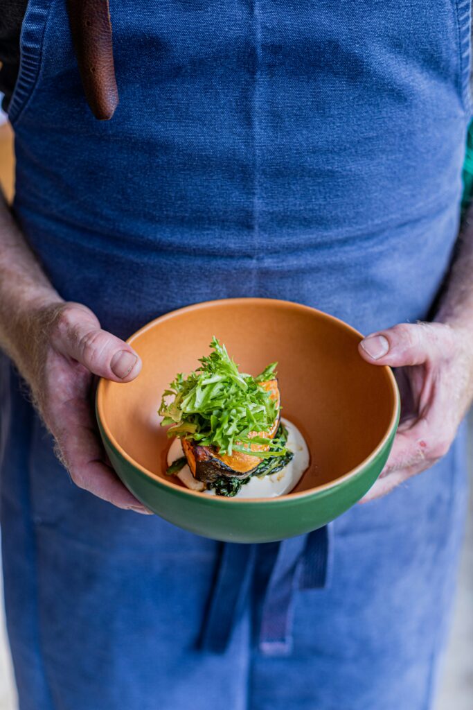 A person enjoying a fresh, colorful Mediterranean salad bowl mindfully